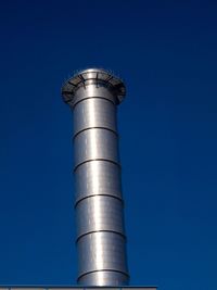 Low angle view of water tower against blue sky