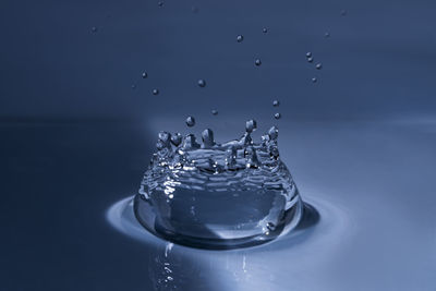 Close-up of splashing water drop hitting water surface