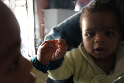 Close-up of cute baby reflecting on mirror