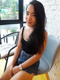 Portrait of smiling young woman sitting on floor