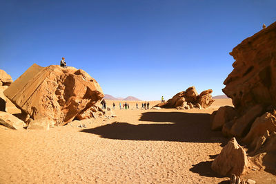 Travelers visiting amazing rock formations in eduardo avaroa andean fauna, sur lipez, bolivia