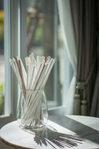 Close-up of drinking straws in glass on table