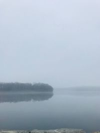 Scenic view of lake against sky at foggy weather