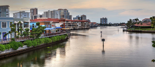 River amidst buildings in city against sky