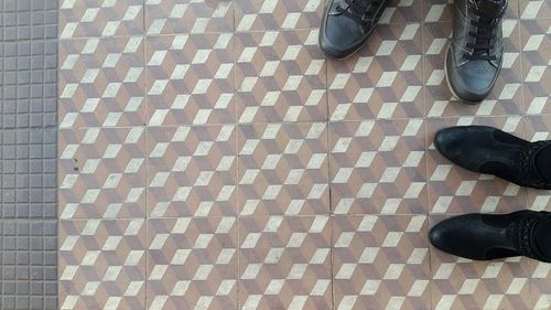 Low section of man standing on tiled floor