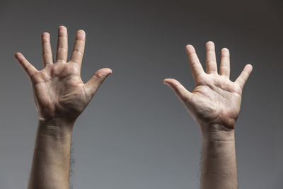 Cropped image of man hand against gray background