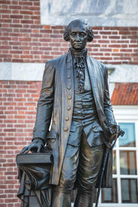 Close-up of statue against brick wall