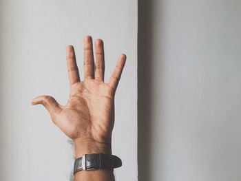 Close-up of person hand against wall