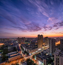 High angle view of illuminated cityscape against sky during sunset