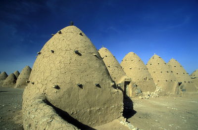 Traditional houses in village against sky