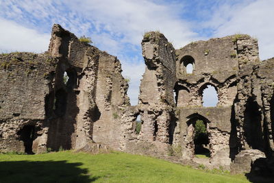 Low angle view of old ruin building against cloudy sky