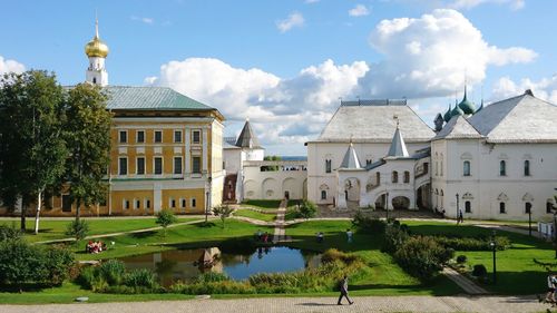 Side view of man walking by castle buildings against sky