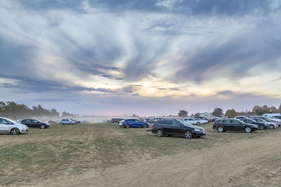 Cars on road against sky during sunset