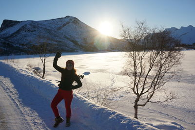 Full length of woman standing on snow covered field