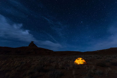 Scenic view of illuminated tent on field against sky at night