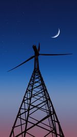 Low angle view of electricity pylon against sky at night