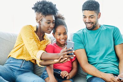 Portrait of happy friends sitting on mobile phone