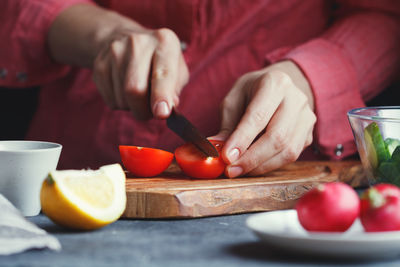 Midsection of woman cooking food at table