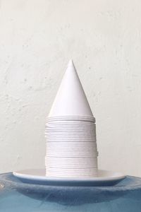 Close-up of white stack on table against wall