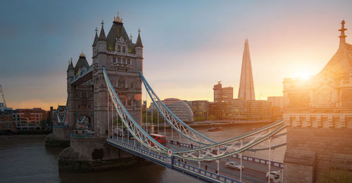 Tower bridge and buildings against sky during sunset