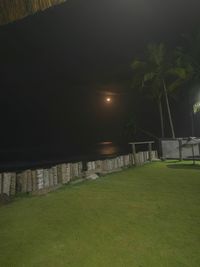 Illuminated park on field against sky at night