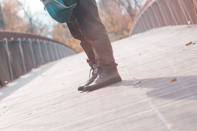 Low section of man standing on footbridge