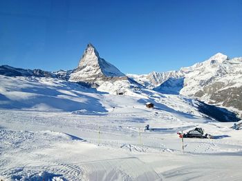 Scenic view of snowcapped mountains against clear blue sky