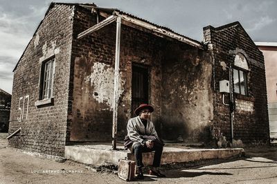 Man standing by old building