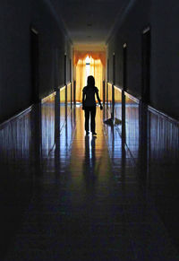 Rear view of silhouette woman walking in corridor