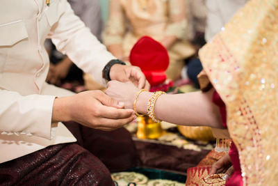 Midsection of couple holding hands