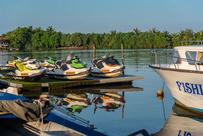 Boats moored in lake against sky