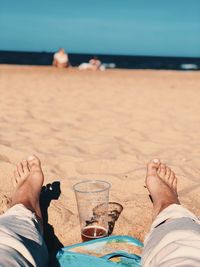 Low section of man relaxing at beach