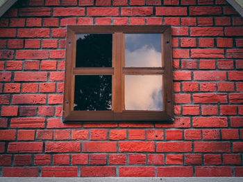 Low angle view of window on brick wall