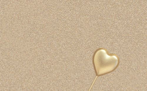 Close-up of heart shape on sand