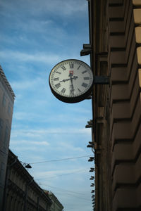 Low angle view of clock against buildings in city