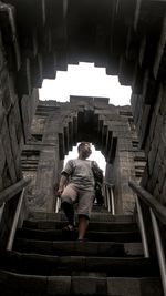 Rear view of woman walking on staircase in building