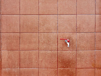 Water faucet with splashing water droplets on the wall