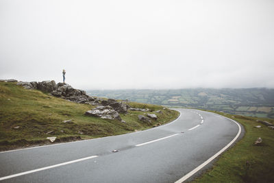 Scenic view of road by land against sky