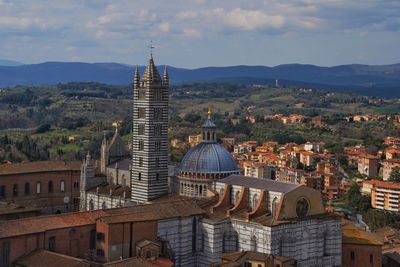 Duomo di siena in city against sky