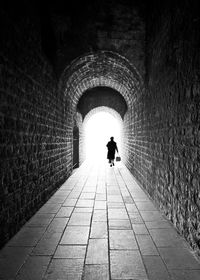 Rear view of man walking in tunnel