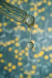 A dripping pipette with a drop of cosmetics gel.