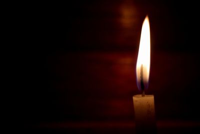Close-up of burning candle in darkroom