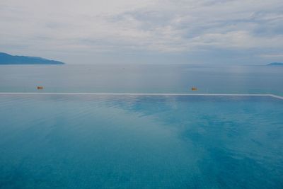 Scenic view of swimming pool by sea against sky