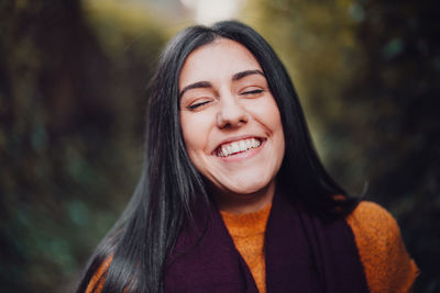Close-up of smiling woman standing in forest