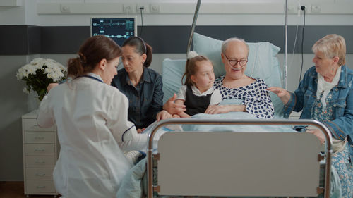 Doctors and people sitting at hospital