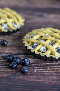 Small cups of delicious blue berry tart or pie on wood table background.