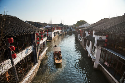 Canal amidst buildings against clear sky