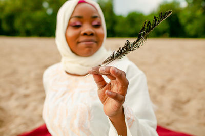 Portrait of young woman holding plant