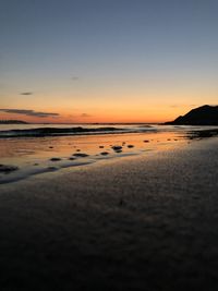 Scenic view of beach against sky during sunset