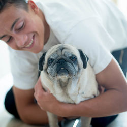 Teenage boy holding pug